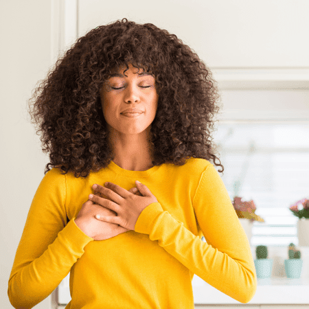 A woman with eyes closed, pausing to be grateful