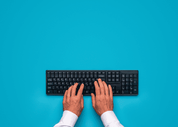 Hands typing on a wireless computer keyboard