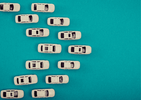 Turquoise background with two rows of white cars